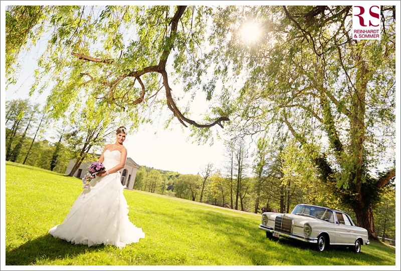 Braut auf Hochzeitsfoto mit Mercedes Oldtimer im Schloßpark Braut auf Hochzeitsfoto mit Mercedes Oldtimer im Schloßpark