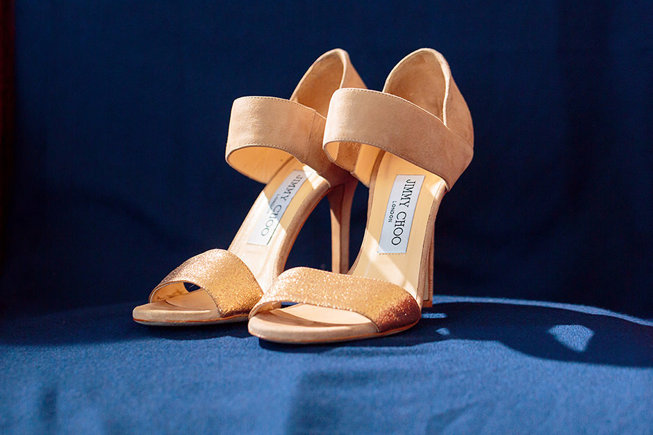 leuchtende Jimmy Choo Brautschuhe vor blauem Hintergrund leuchtende Jimmy Choo Brautschuhe vor blauem Hintergrund