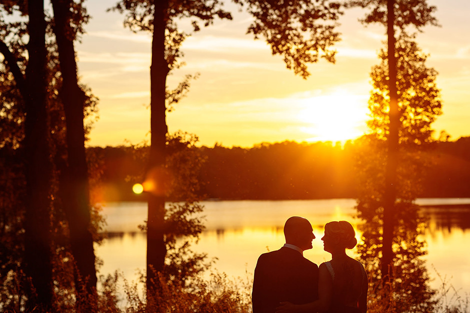 Hochzeitsfoto mit Silhouette vom Brautpaar am See in Brandenburg im gelb leuchtenden Abendlicht Hochzeitsfoto mit Silhouette vom Brautpaar am See in Brandenburg im gelb leuchtenden Abendlicht