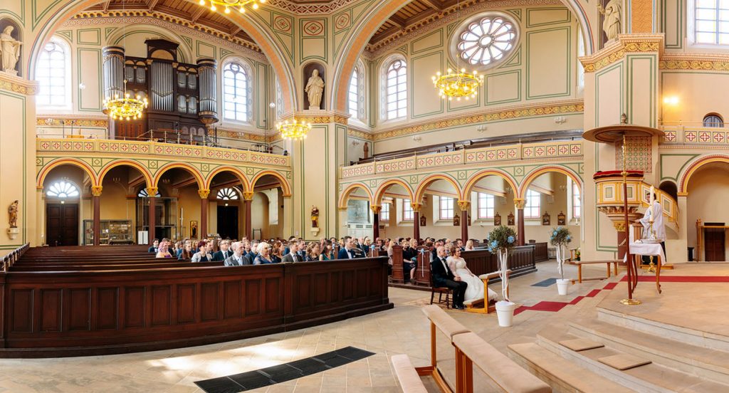 Ein Blick auf das Brautpaar, die Gäste und das Innere der Peter und Paul Kirche Potsdam während der Trauung