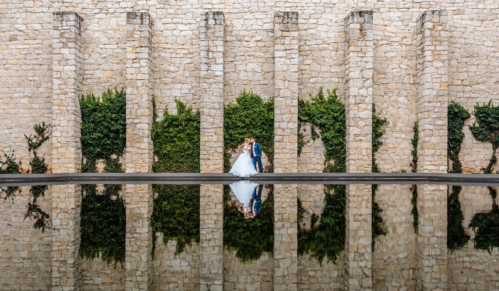 Hochzeitsfoto mit Brautpaar und Spiegelung im Wasser des Belvedere PotsdamDer Innenhof mit Wasserbecken