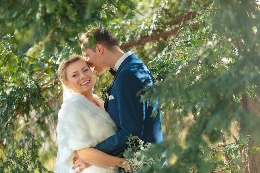 Hochzeitspaar im Winter mit der Sonne im Rücken