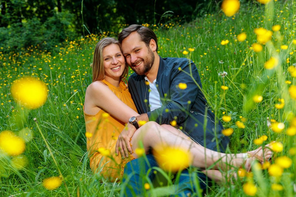 Pärchen sitzt auf Blumenwiese im Schlosspark Potsdam
