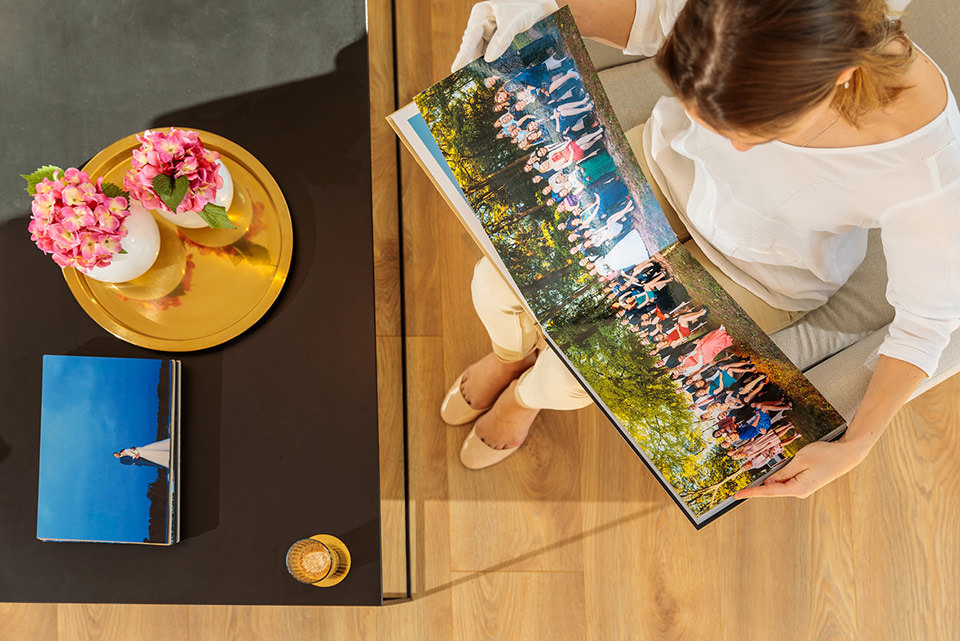 Gast guckt sich Gruppenbild als Panorama im Hochzeitsfotobuch an Gast guckt sich Gruppenbild als Panorama im Hochzeitsfotobuch an