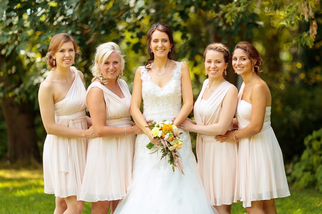 Die Braut mit ihren Brautjungfern in cremefarbenen Outfits
