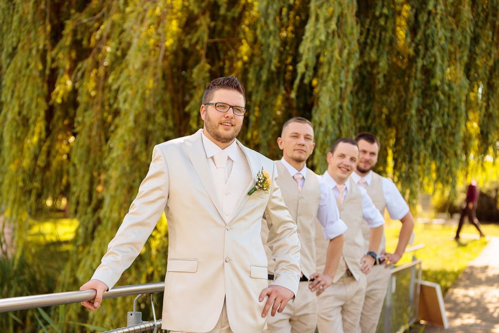 Der Bräutigam mit seinen Freunden in sommerlichen Outfits