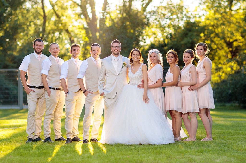 Braut und Bräutigam mit Freunden in cremefarbenen Outfits