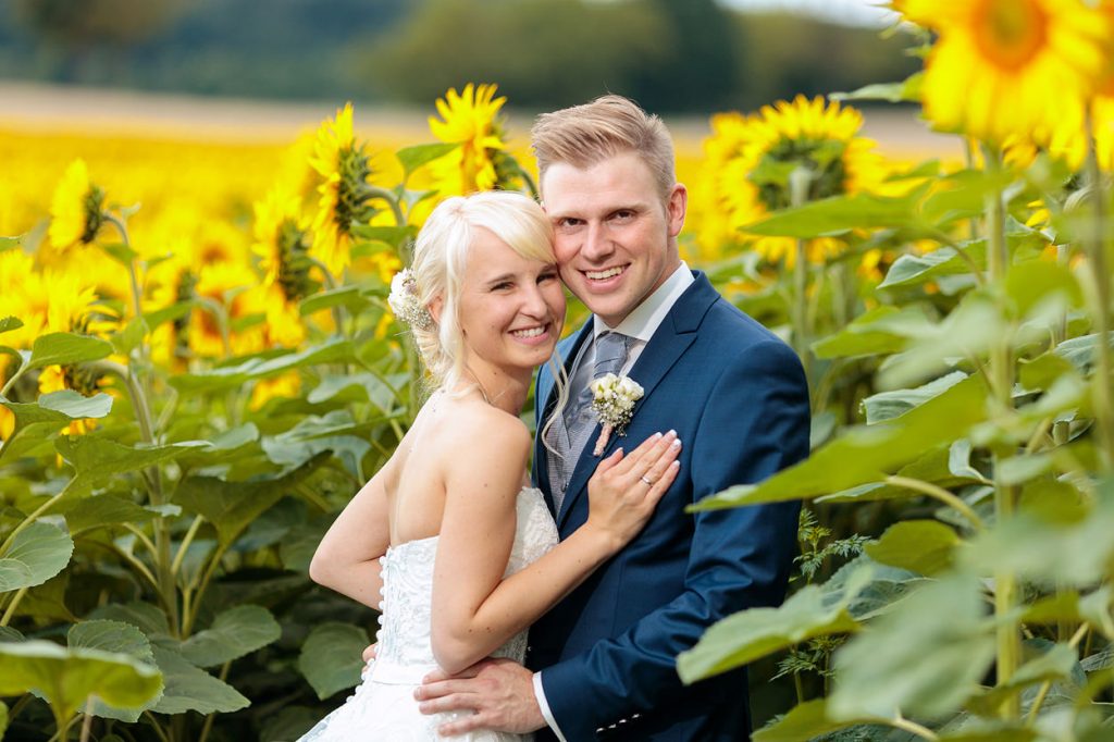 Ein Brautpaar im Sonnenblumenfeld in Beelitz
