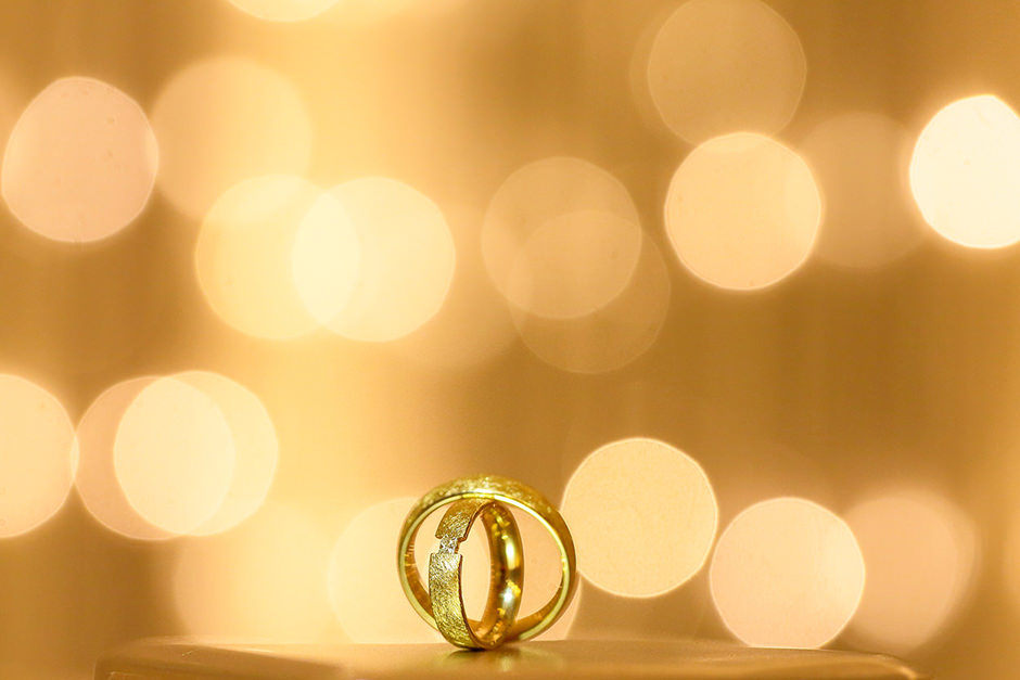Goldene Trauringe mit leuchtendem Bokeh Goldene Trauringe mit leuchtendem Bokeh