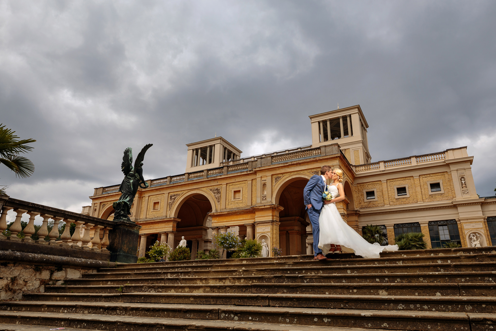 Hochzeitsfotograf fotografiert Brautpaar vor Orangerie am Tag der Hochzeit in Potsdam