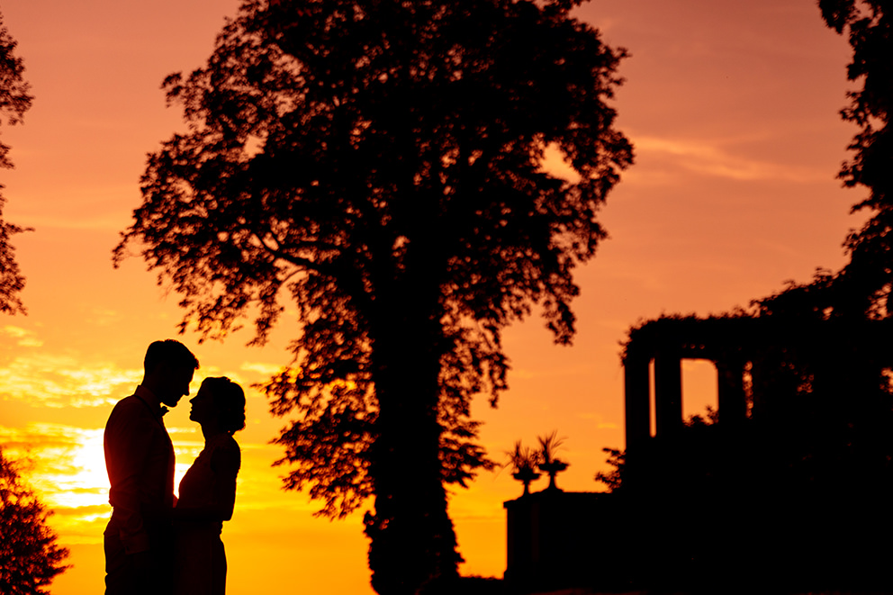 Silhouette von einem Brautpaar im Hochzeitsbild Hochzeitsfotograf Berlin fotografiert Silhouette von Hochzeitspaar am Schloss Glienicke in Wannsee