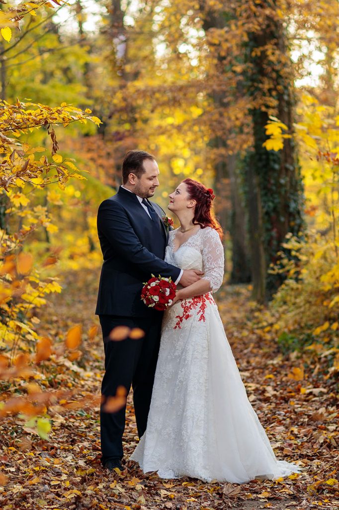 Ein Brautpaar im Wald mit Herbstlaub