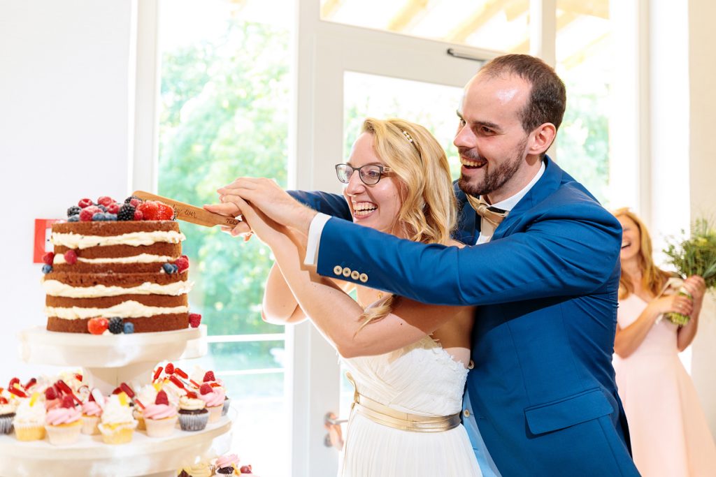 Anschnitt der Hochzeitstorte durch das Brautpaar im BlauArt Tagungshaus