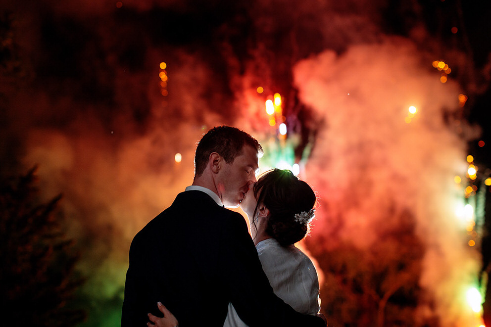 Ein Kuss zwischen dem Brautpaar unter dem Feuerwerk auf dem Landgut Stober