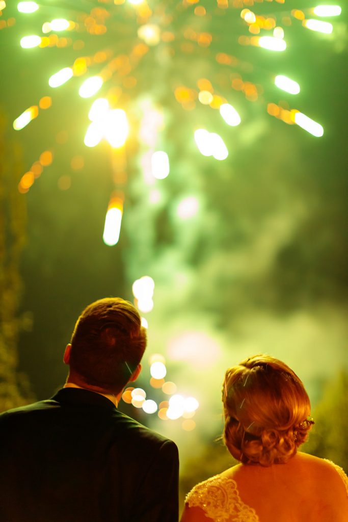 Das Brautpaar beobachtet Seite an Seite das Feuerwerk