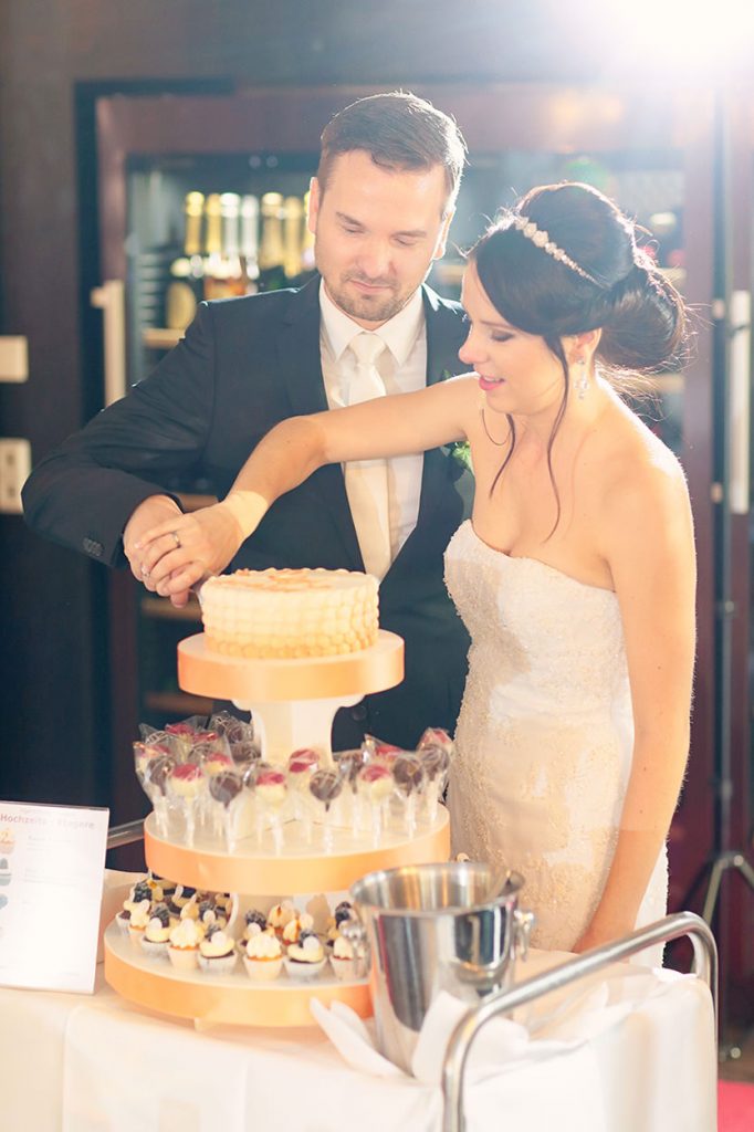 Das Brautpaar schneidet die Hochzeitstorte an
