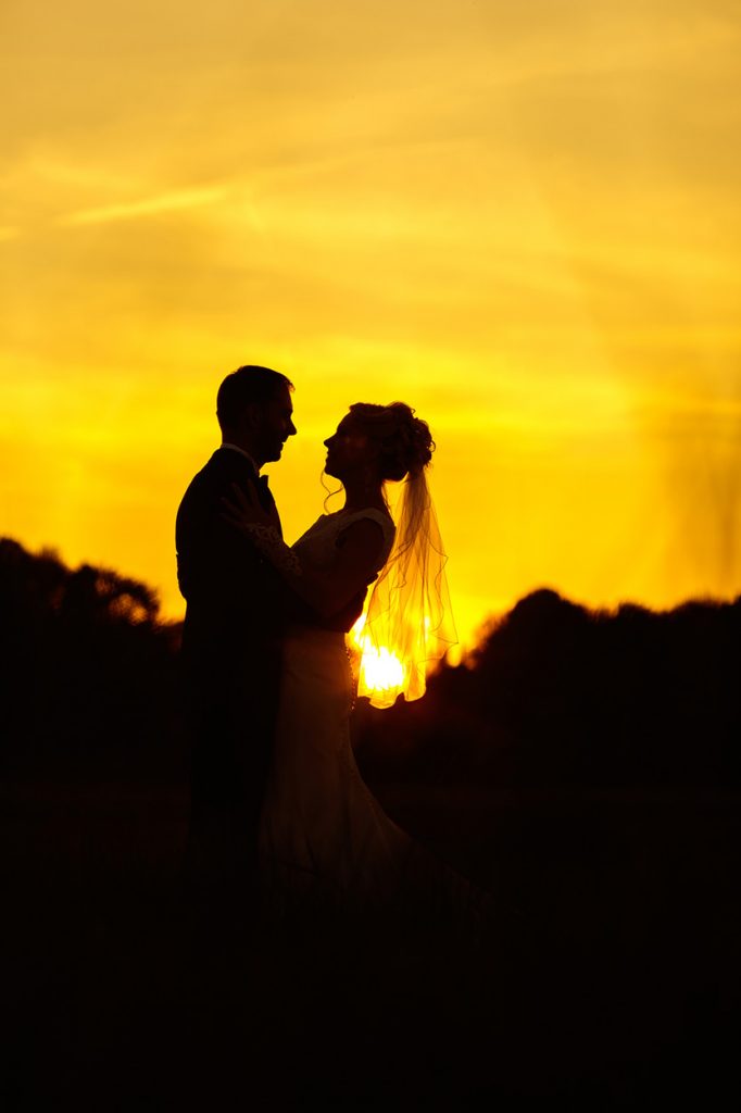 Das Brautpaar als Silhouette im Sonnenuntergang
