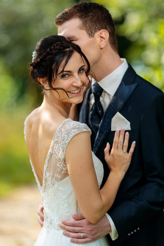 Braut mit ärmellosem Brautkleid strahlt in die Kamera Eine strahlende Braut am Hochzeitstag auf dem Landgut Stober bei Nauen
