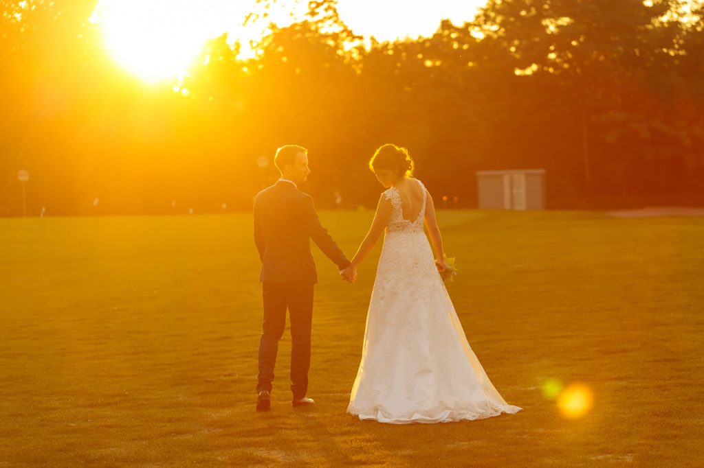 Das Brautpaar spaziert dem Sonnenuntergang entgegen