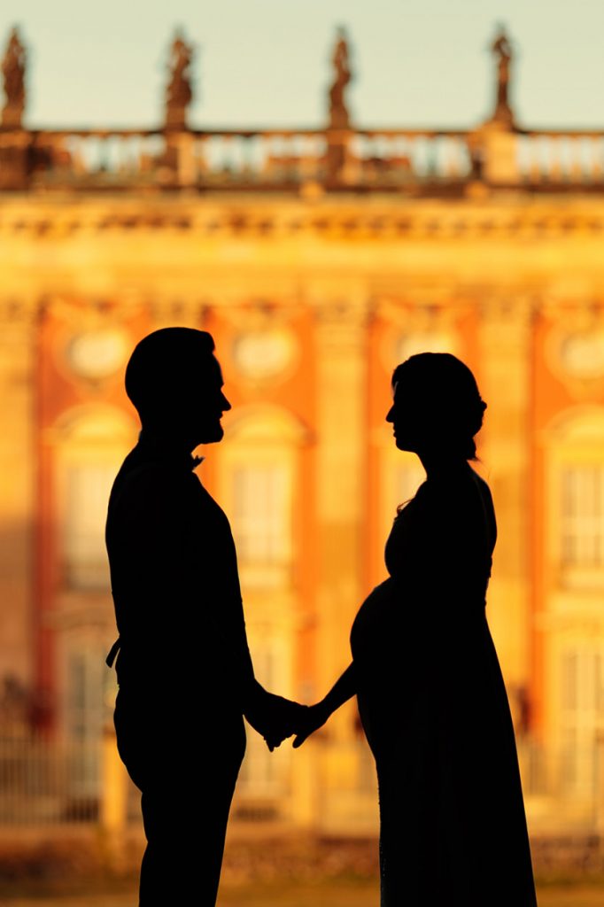 Eine schwangere Braut und ihr Bräutigam beim Sonnenuntergang am Neuen Palais Potsdam