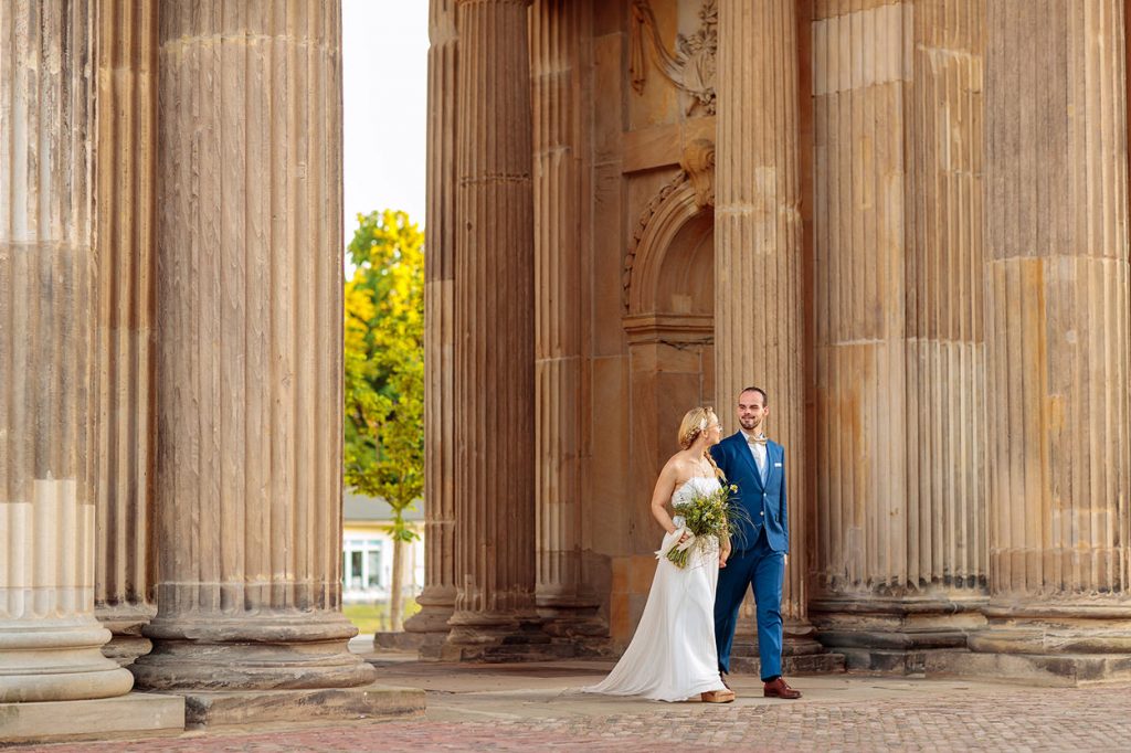 Das Brautpaar schlendert durch die Säulengänge am Neuen Palais in Potsdam
