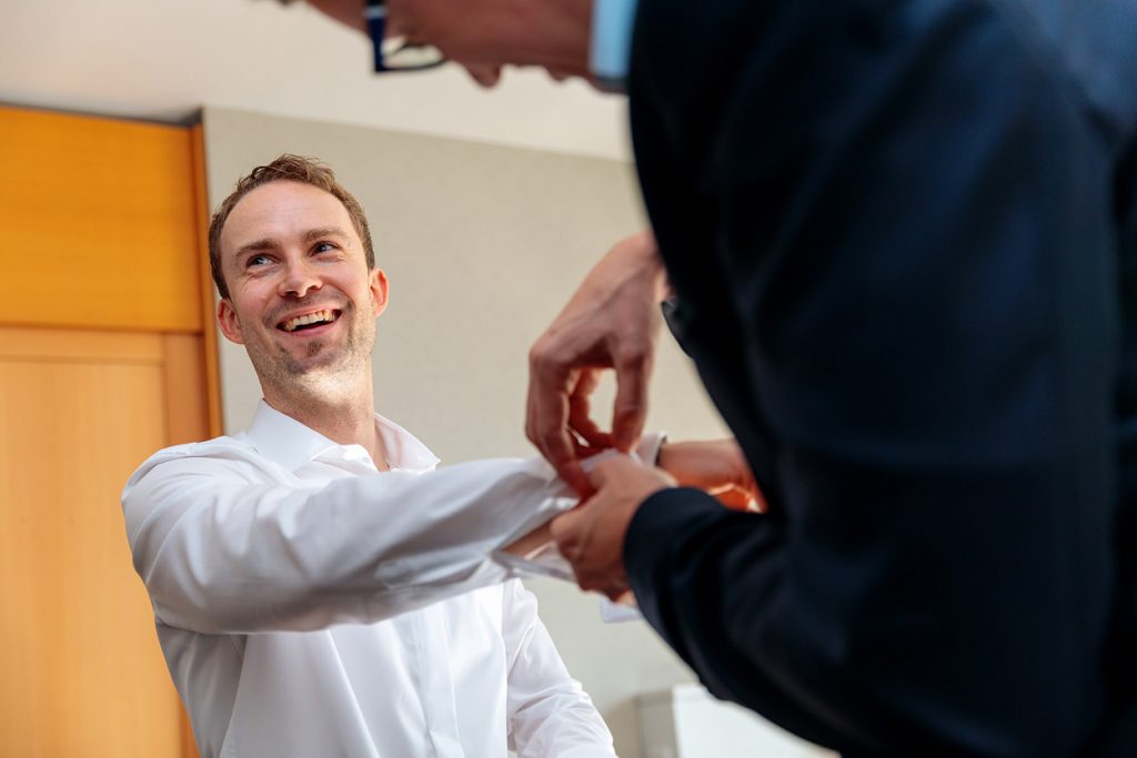 Der Bräutigam in bester Stimmung beim anziehen