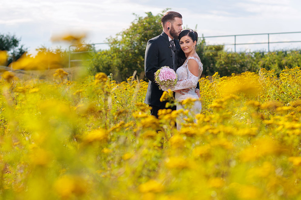 Hochzeitspaar im Blumenfeld