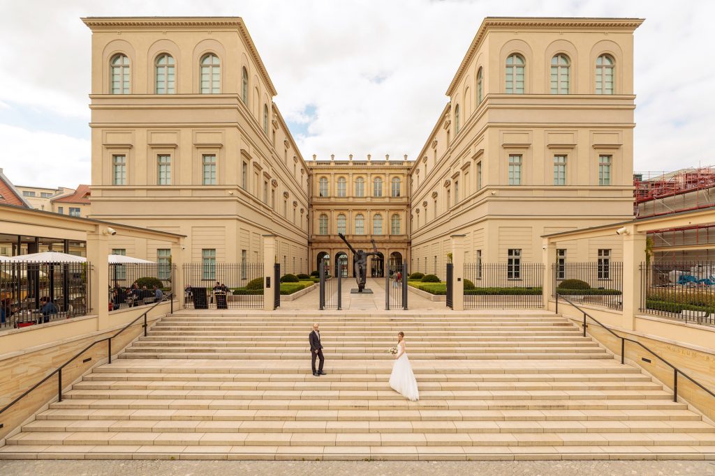 Das Hochzeitspaar wird im Sommer vor dem Museum Barberini in Potsdam im Rahmen einer Hochzeitsreportage fotografiert