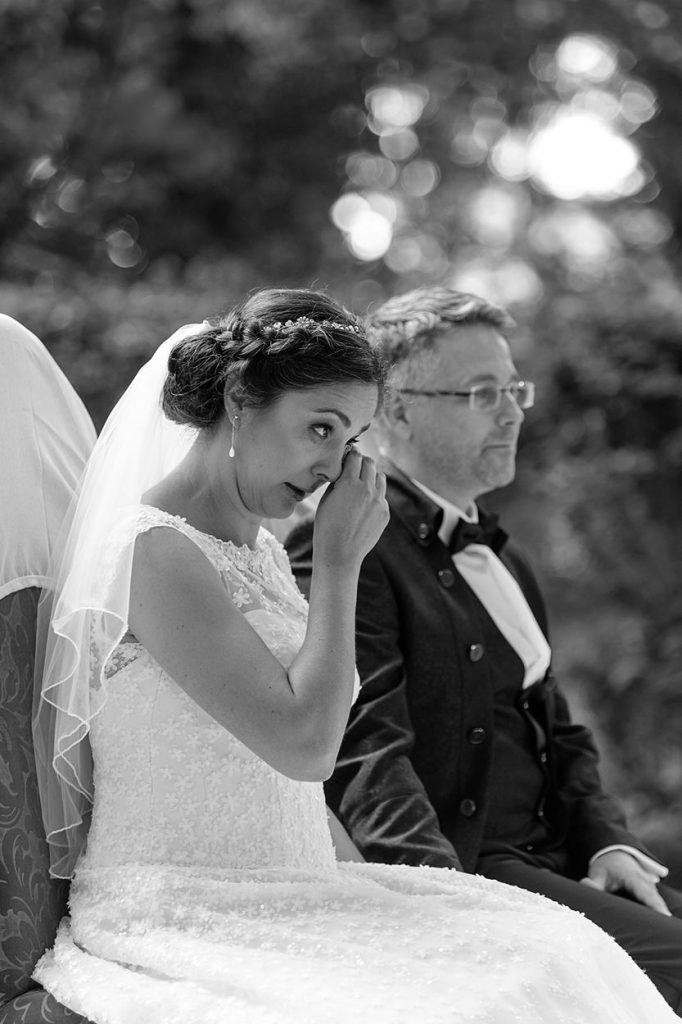 Eine emotionale Trauung im Park von Schloss Blankensee, bei der sich die Braut eine Träne aus dem Gesicht wischt