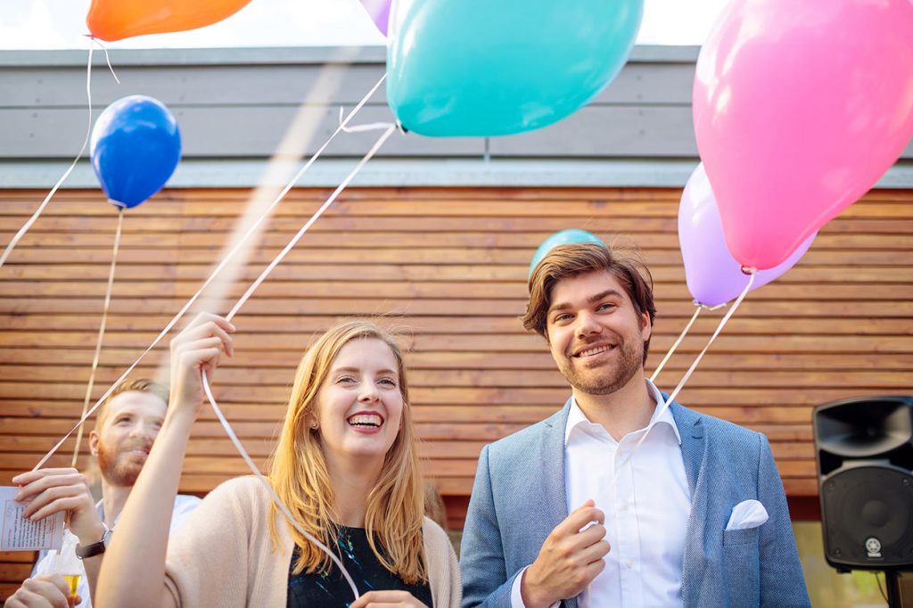 Hochzeitsgäste mit Luftballons bei der Hochzeitsfeier am Yachthafen am Wannsee im Sommer