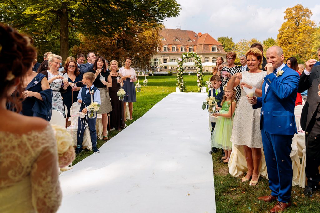 Die Hochzeitsgäste beglückwünschen das Brautpaar nach der freien Trauung im Park von Schloss Kartzow Potsdam