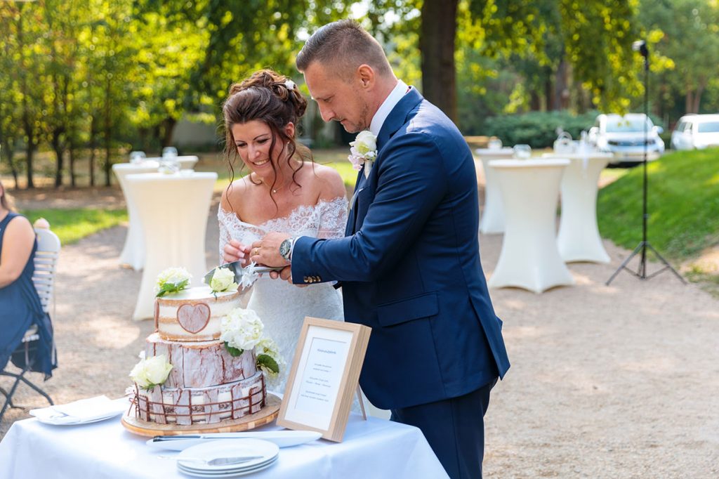 Anschnitt der Hochzeitstorte, die als besonderes Geschenk von der Trauzeugin gebacken wurde