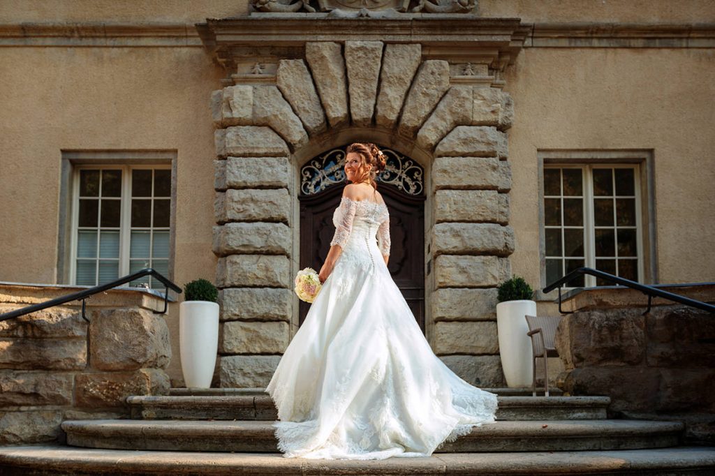 Eine Braut auf einem Foto bei einer Hochzeit auf Schloß Kartzow bei Potsdam Die Braut auf den Treppenstufen vom Schloss Kartzow Potsdam