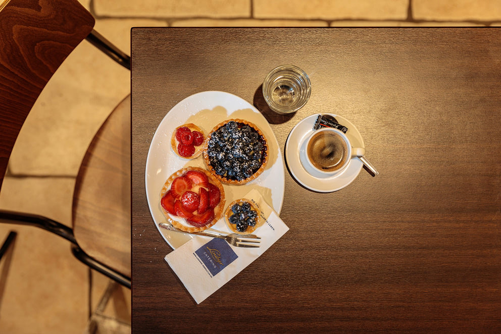 Törtchen und Backwaren mit Espresso und einem Wasser für ansprechende Food-Bilder