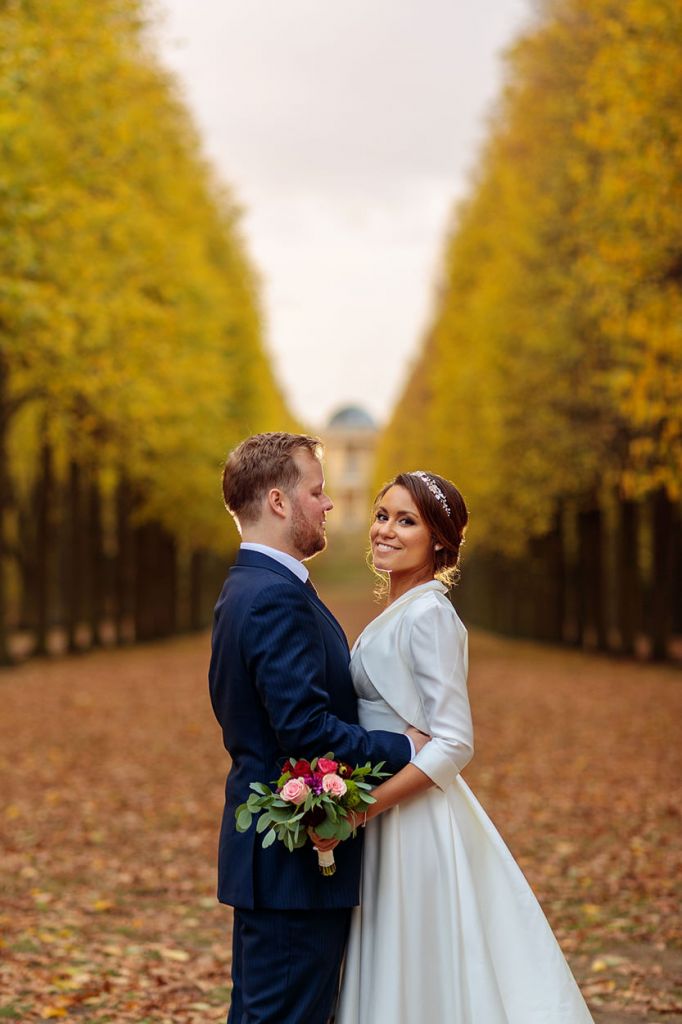 Brautpaar zwischen einer herbstlichen Baum Allee