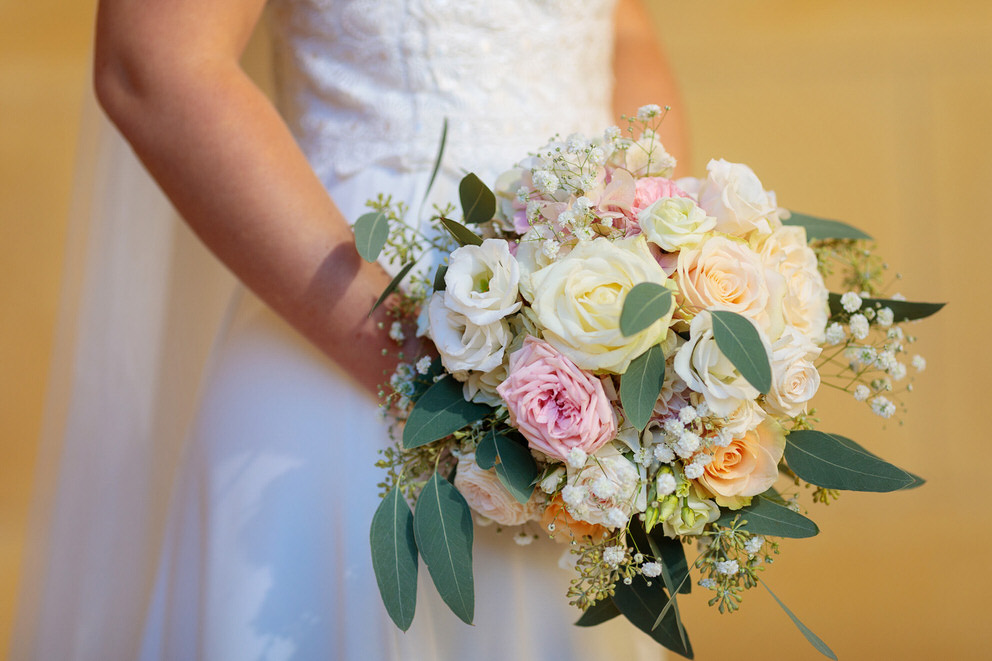 Brautstrauss mit Rosen und Pfingstrosen vor gelber Wand Brautstrauss mit Rosen und Pfingstrosen vor gelber Wand