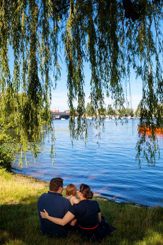 Familie sitzt am Ufer und blickt auf See