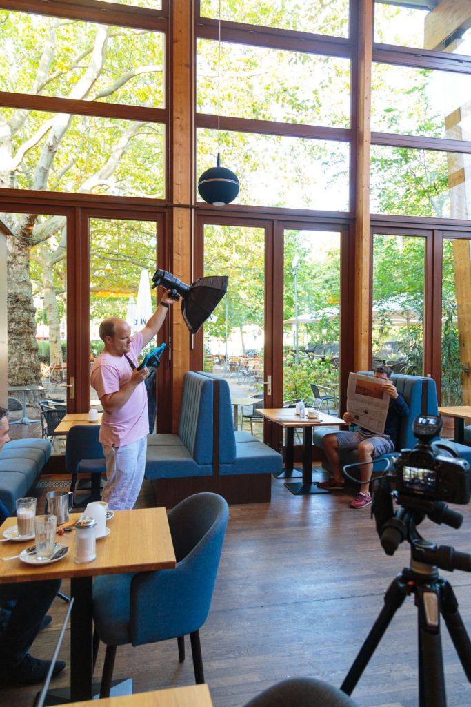 Fotograf hält Blitz und Ipad für Fotoaufnahme