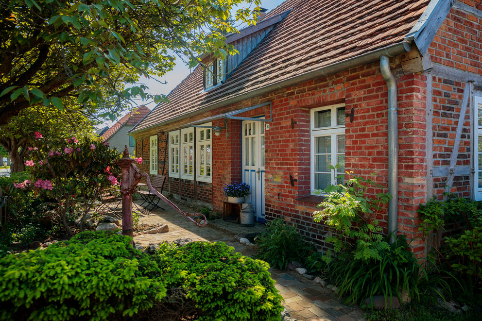 Uriges Ferienhaus aus Backstein mit viel Grün.