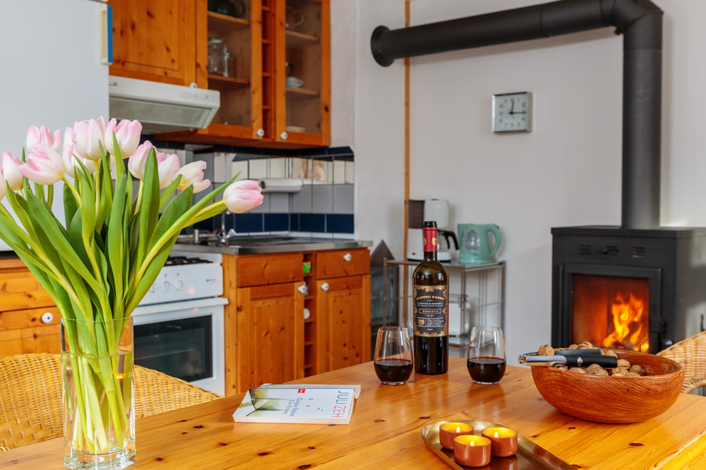 Kamin in Ferienhaus mit einem Glas Rotwein