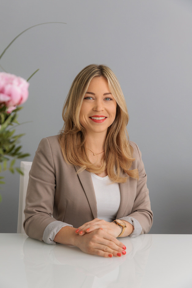 Frau sitzt in Maklerbüro für Portraitfotos des Personals